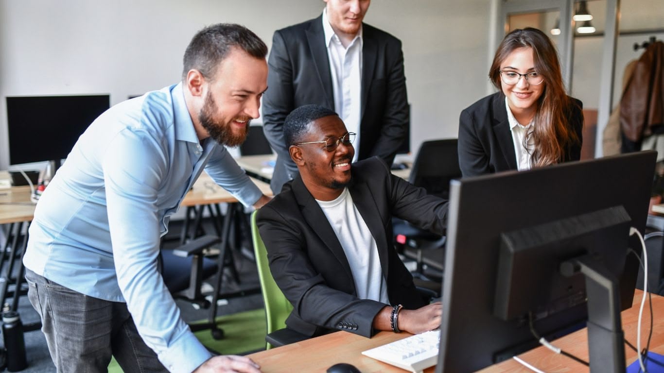 Colleagues discussing the best AI search platform while gathered around a desk